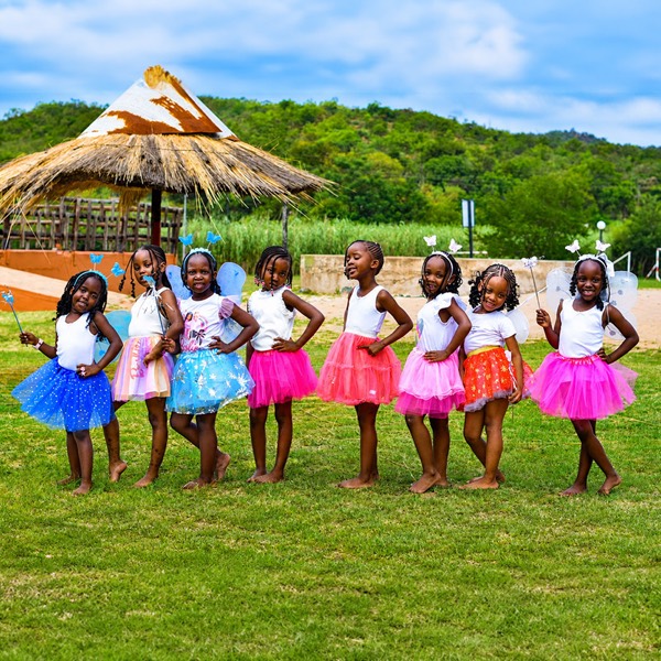 Girls from Zonke Izizwe in tutus and fairy wings on the grass